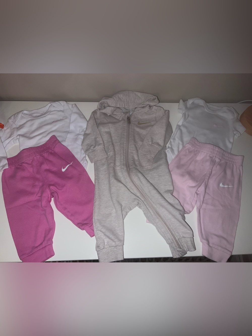 Three (6M) Nike outfits. 2 matching sets 1 romper